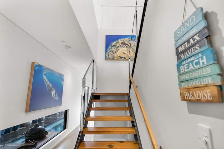 Open timber staircase with reef photography on the walls.
