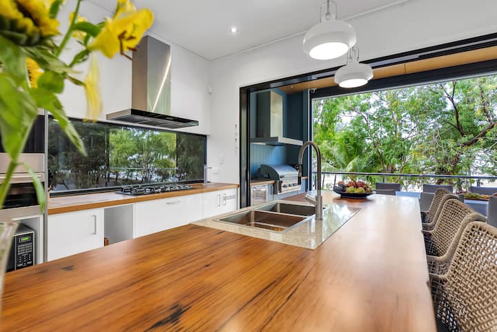 Kitchen island with a recycled timber bench top, looking out to the balcony.