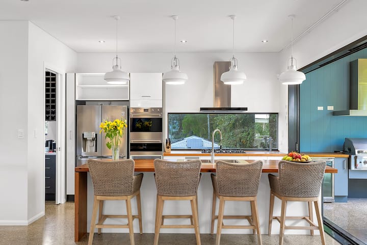 Kitchen with breakfast bar and stools, double oven and timber bench tops.