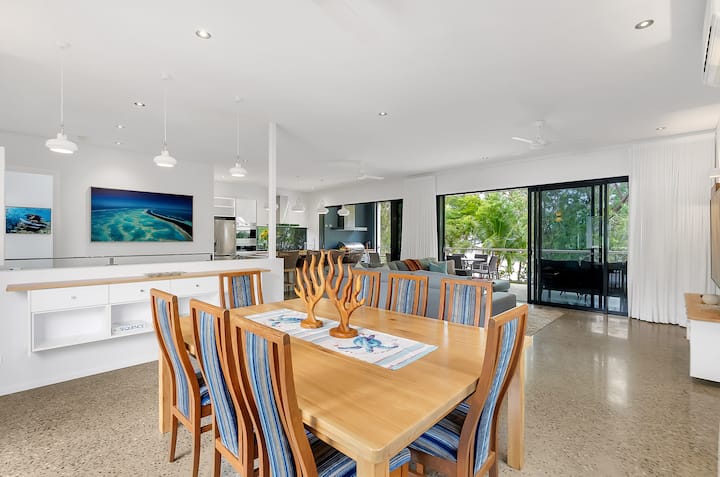 Open-plan upper level with dining table, kitchen and lounge.