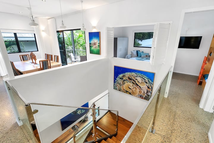 Stairwell with recycled timber, polished concrete floor and reef photographs.