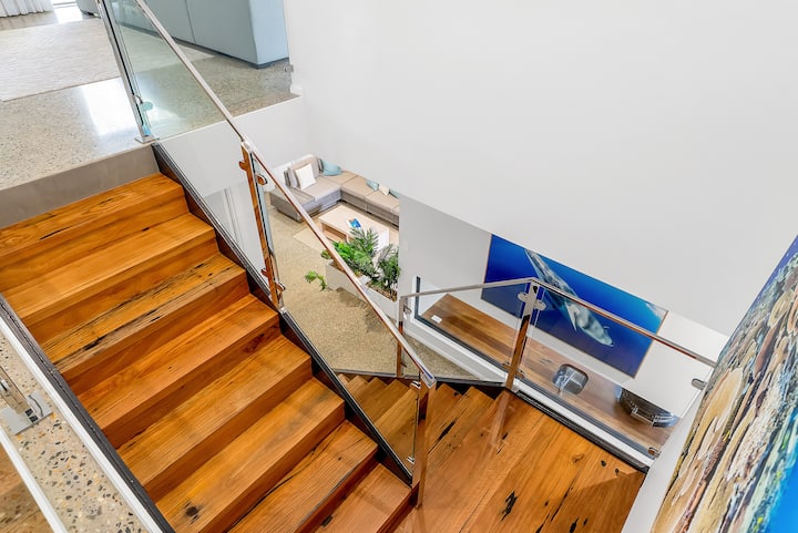Recycled hardwood staircase, with a whale photograph in the hallway below.