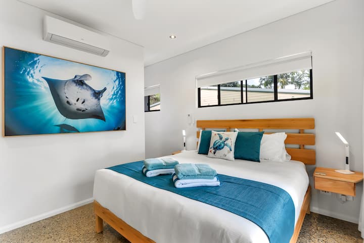 Manta Room master bedroom with a handmade timber king bed and a large manta ray photograph.