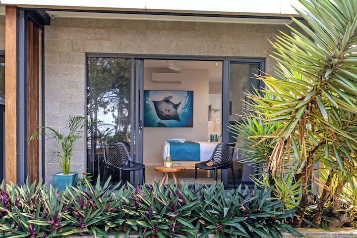 Master bedroom seen from the patio garden, with a manta photograph on the wall.