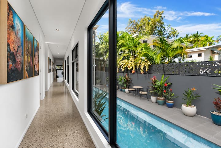 Hallway lined with reef photographs, with the pool through the glass.